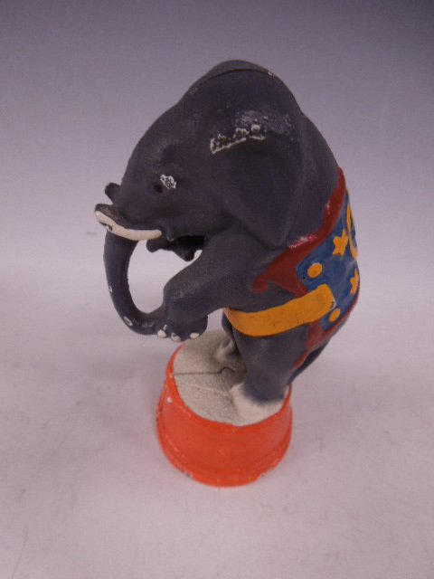 Cast Iron Still Bank: Cast iron still bank, circus elephant on barrel, hand painted, flat head screw. CONDITION: Some paint loss on elephant at barrel.