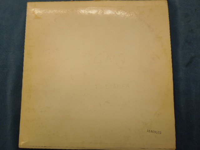 The Beatles "White" Album: The Beatles "White" album, serial number A1469575, Apple - SWBO-101. Comes with poster & pictures. CONDITION: Wear & tear on sleeve, very minor scratches, owners name on labels.