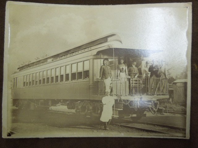 Fine PRR John Wanamaker Family Private Car Photo: Fine and rare Pennsylvania Railroad private car photograph, c. 1895. Ink inscription verso: "Private Car of Rodman Wanamaker / Left to Right/ Rodman Wanamaker, May Roberts (Mrs. Geo. W.R.R.)" G.W.R. R