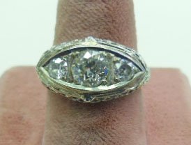 18k Deco 3 Diamond Ring: 18k Deco 3 Diamond Ring, 18K tested WG filigree ring, horizontal marquise shaped mounting supports an approx 1 ct. round mine cut center diamond with two approx 1/4 ct. each round modern cut diamonds.