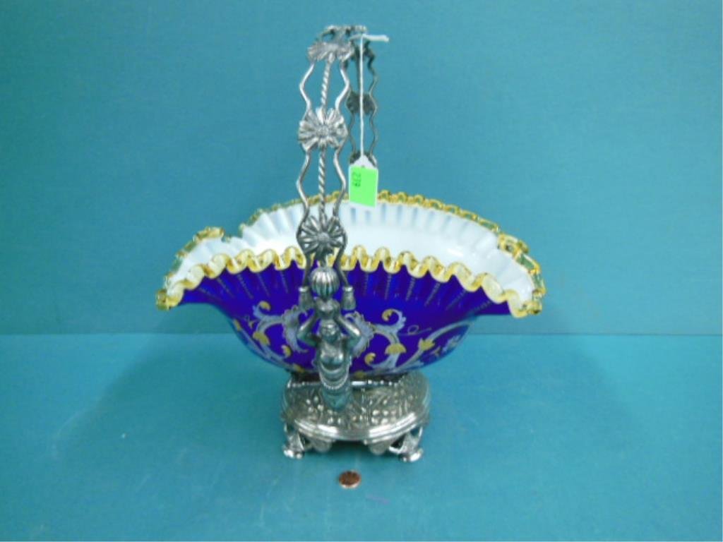 Victorian Brides Basket: Victorian Brides Basket, cobalt over white cased glass with applied ruffled amber glass rim, mask, scroll and floral gilt and enameling; rests in Simpon - Hall-Miller Co. Quadruple plate stand with ny