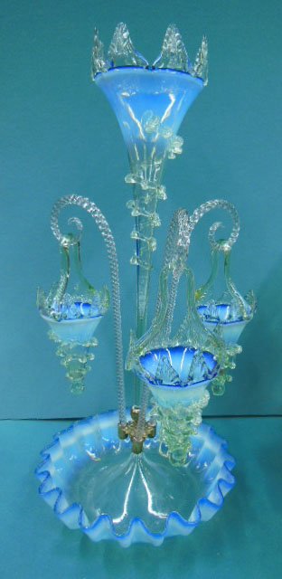 Victorian Basket Epergne: Victorian basket epergne, in blue to opalescent glass with applied pale green trim, the fluted and scalloped bowl supports a trumpet vase and 3 clear glass rope twist rods holding trumpet form baskets