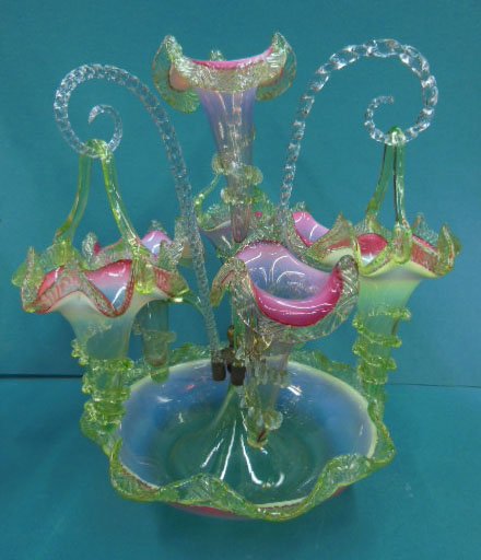 Victorian Basket Epergne: Victorian Basket Epergne in cranberry, opalescent to green glass, the scalloped bowl base supports a trumpet center vase and 3 side vases; 3 clear glass rope twist rods hold conforming trumpet form ba