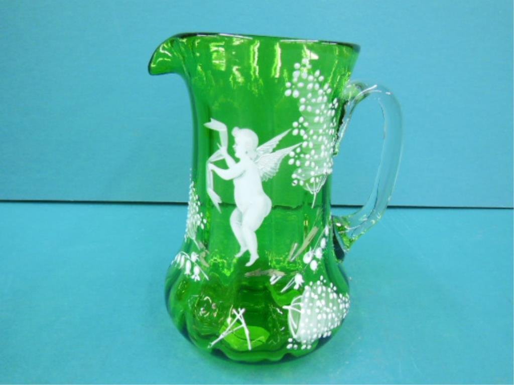 Mary Gregory Type Green Pitcher: Mary Gregory type green pitcher, white & some gilt enameling, cherub with scarf, lilies of the valley & bushes. Green ribbed glass 7 1/4". Applied clear handle Victorian late 19th c. CONDITION: Very f