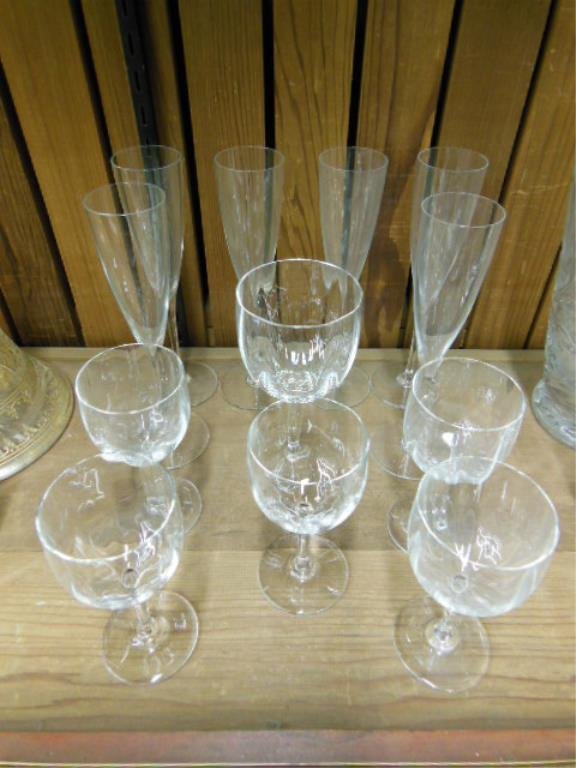 12 Pcs Baccarat Stemware: Twelve pieces Baccarat stemware, six champagne flutes, one water glass & five wines. Montaigne Optic pattern for wines & water, Dom Perignon pattern for champagnes. CONDITION: Very good.