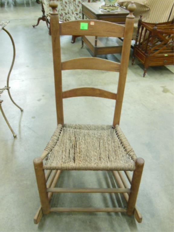 Shaker Style Nursing Rocker: Shaker style nursing rocker, mixed woods, three arched ladder slats, rush seat, 19th C., 38" h. CONDITION: Broken strand in rush seat, no finish to wood.