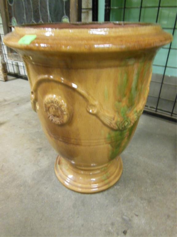 French Anduze Redware Flower urn: French Anduze Redware flower urn, glazed orange with green accents, raised floral ribbon & medallions (marked LA Madeleine Anduze), 17" d (at top), 21" h. CONDITION: No issues identified.