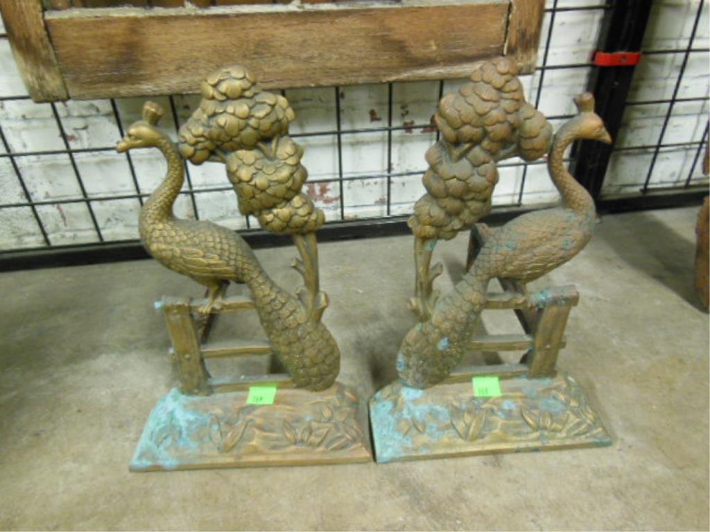 Pair Bronze Peacock Andirons: Pair of bronze peacock andirons, the peacock rests on a fence alongside a tree, early 20th C., 17 1/2" h. CONDITION: Water stained & tarnished, rusted iron log supports.