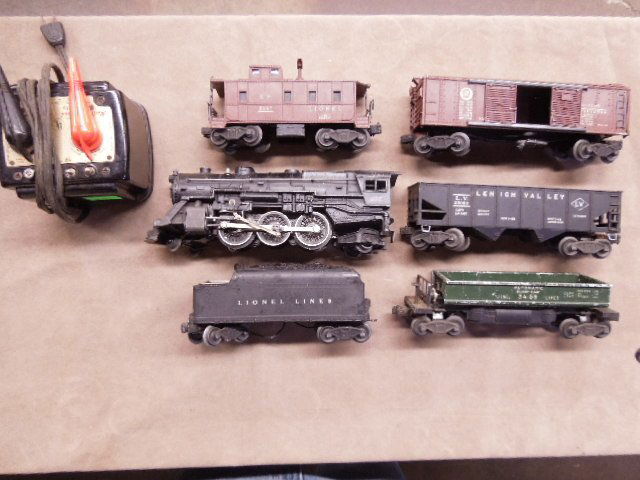 Vintage Lionel O-Scale Train Lot: Vintage Lionel O-Scale Train lot includes: #675 Locomotive and Tender, 4 cars and Model 1033 Transformer. CONDITION: Fair, used, shows wear and some breakage.