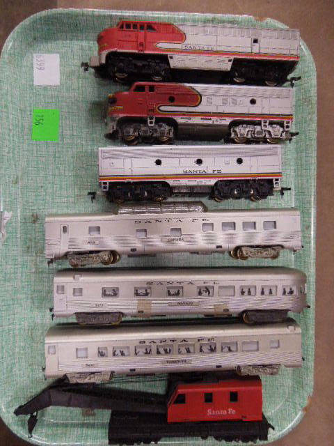 Santa Fe HO-Scale Train Lot: Santa Fe HO-Scale train lot includes: 2 locomotives, 1 Tender, 1 Crane car, and 3 passenger cars. Made by Penn Line, Tyco and other. CONDITION: Fair, used, shows wear.
