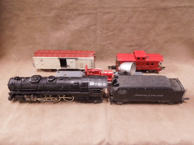 American Flyer Train Lot: American Flyer train lot, includes: #322 engine & #518 tender, #633 B & O boxcar, #7210 searchlight car, #638 caboose. CONDITION: Fair, used.