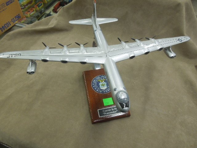 Air Force Convair B-36 Model Plane: "Peacemaker", jet engines (at end) with 6 movable prop "rear wing" engines, attached to wood stand with Air Force logo, 16" x 22". CONDITION: Minor surface wear, missing one prop, blade off each engin