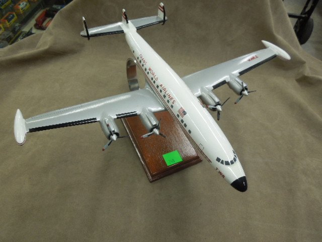 TWA Super 6 Model Plane: Composition, white with silver wings, 4 engine, movable prop, attached to wood stand, 15 1/2" x 20". CONDITION: Minor surface wear.