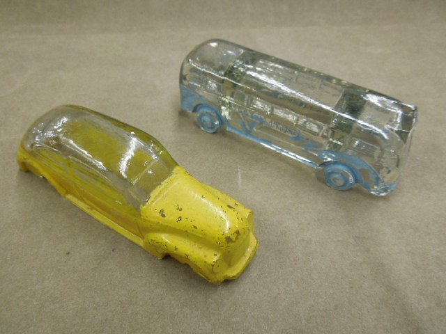 2 Vehicle Glass Candy Containers: Two vehicle glass candy containers, one bus "Victory Lines", light blue to clear, 5" & one car, yellow to clear, 4 7/8". CONDITION: Paint loss on both pieces, car missing wheels, otherwise minor wear.