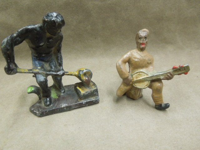 2 African American Lead Figures: African Amer lead figures, one man smelting iron, 3" & one man playing banjo. CONDITION: Some paint loss on both pieces.