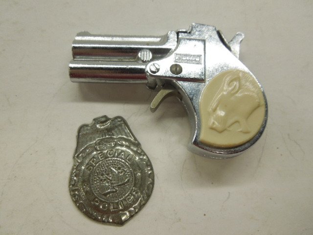 Toy Cap gun & badge: Hubley toy cap gun, plastic mounts on handle featuring "Wildcat" 4", plus tin "Special Agent" badge 2" Condition; some wear on badge, minor wear and surface scratching on gun
