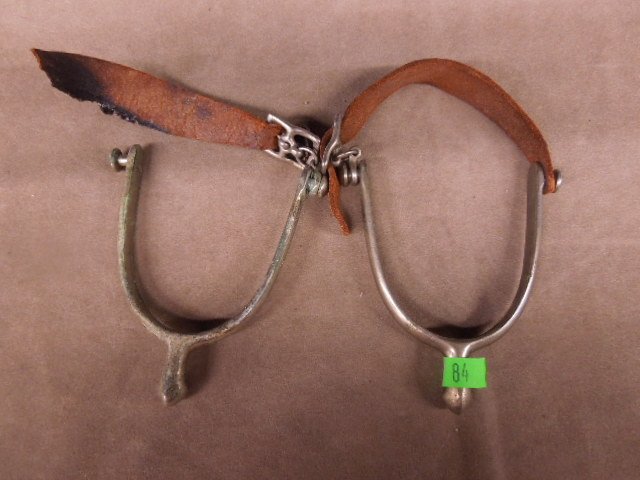 Pr. metal spurs w/ leather straps: Pair metal spurs with leather straps, "never rust" with small star on other end, 5" Condition; some pitting and oxidation, 1 leather strap end missing
