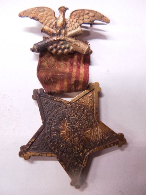 19th c. GAR Veteran Badge: GAR Veteran Badge, 19th c. with Star form medal at bottom, eagle and canon and stars at top, 3", (63B) Condition; bottom medal has wear, flag ribbon faded and stained, top medal has some wear bottom l