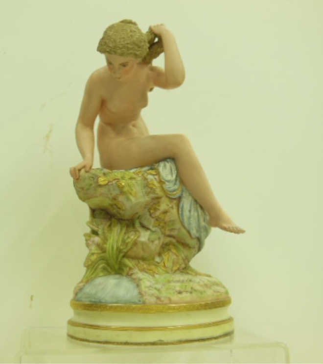 19th c. Robinson & Leadbeater Parian Figure: Late 19th c. Robinson & Leadbeater colored Parian ware 15 1/2" (h) x 9" (l) x 7" (w) figure depicting a seated nude female on a rock base. Incised R & L in an oval mark on backside. [31] CONDITION: Sm