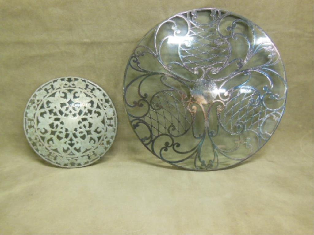 Sterling Silver Overlay Glass Trivets: Lot of two early to mid 20th c. sterling silver overlay crystal glass trivets includes: 6"(d) with a Webster Co. floral and geometric design and 10"(d) with a geometric design. CONDITION: Both have ar