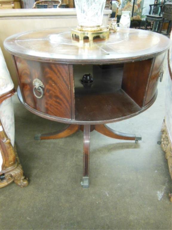 Duncan Phyfe Style Drum Table: Duncan Phyfe style drum table, flame grained mahogany, tooled leather top reeded turned column on 4 sabre legs with brass caps & casters, mid 20th C. CONDITION: Areas of finish wear & scratches.
