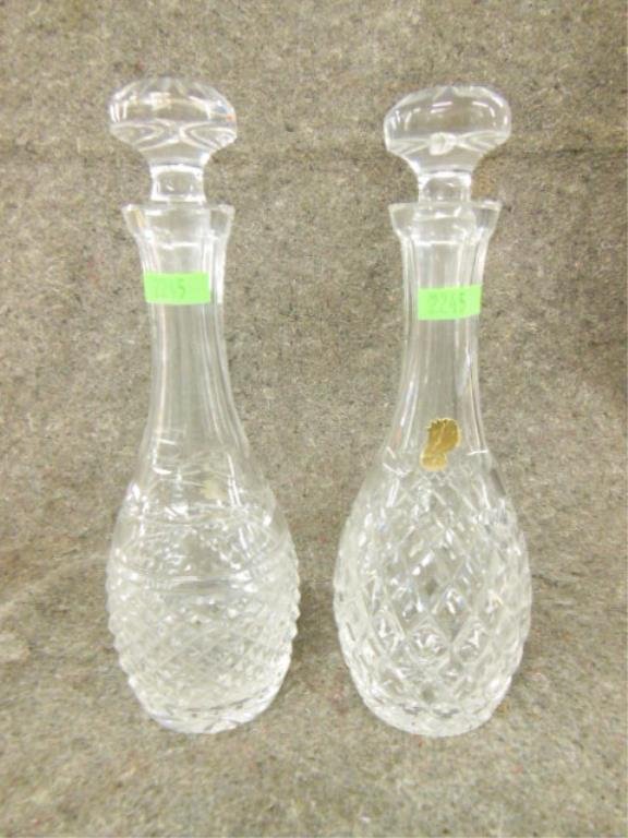 2 Waterford Crystal Decanters with stoppers: 2 Waterford Crystal Decanters with stoppers both with etched mark at bottom, Dunmore pattern. One with paper label. 11.5" each. Cond: Minor roughness on bottom