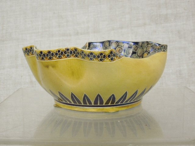 19th C. Zsolnay Pottery Bowl: Late 19th C. Zsolnay Hungarian art pottery 2 1/4" (height) x 5 1/2" (length) x 4 1/2" (width) crimped top bowl, yellow glazed outer body with floral design top border & sunray style designs along base