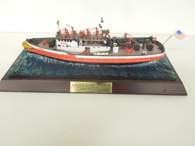 F.D. N.Y. Marine Co.# 9 Fire Fighter Boat: Fire Department New York Marina Co. #9 fire fighter boat, 12 1/2" on plastic simulated water and wood stand, brass plaque. CONDITION: Life boat launch and (1) fire hose broken off, otherwise very mino