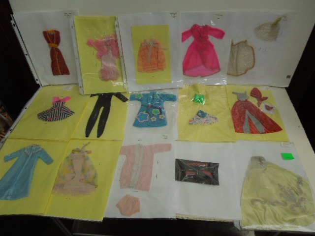 26 Assorted Barbie Outfits: Including: Cinderella and other gowns, robes, night gowns, ballerina tights, dresses, pajamas and other. CONDITION: Some wear from age and use, some outfits may have staples through them, some outfits