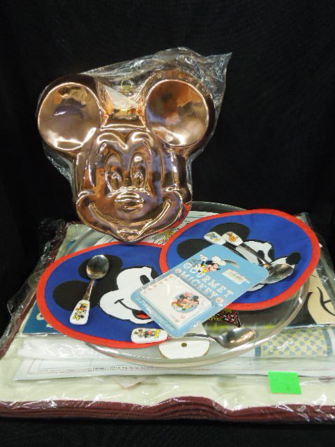Gourmet Mickey & Other Kitchen Items: Kitchen items including: Gourmet Mickey day planner and cutting board, Chief Mickey Apron and Mitt, Disney character table cover, Mickey and Minnie plastic tray, set of four Disney character spoons, t