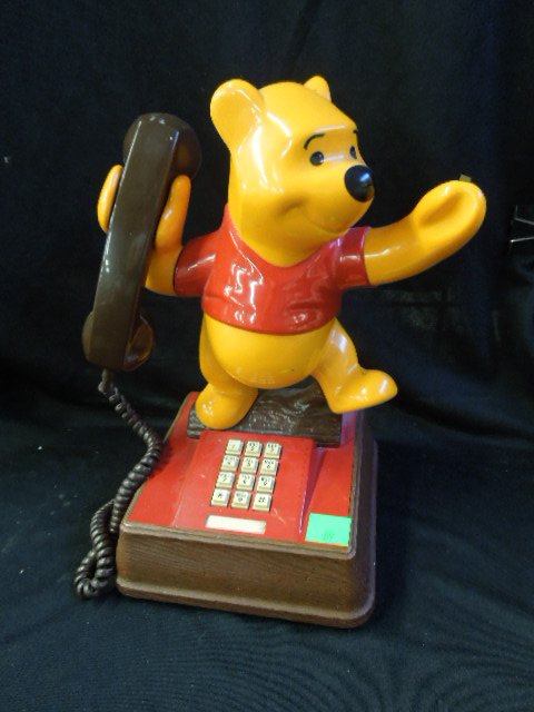 Disney's Winnie the Pooh Phone: Disney's Winnie the Pooh phone, push button with right arm hook (no jack to plug in the wall) Pooh standing on log, 14 1/2". CONDITION: Some wear from age and use, dirty along seams, missing butterfly