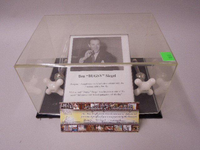 Bugsy Siegal's Faucet Handles: Bugsy Siegal's faucet handles, hot and cold porcelain with value pipes, for bathroom, 3 1/4" x 3 1/4" (at x) with certificate of authenticity (Star Wares), in plastic cube. CONDITION: Minor wear from 