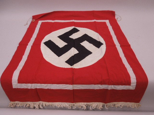 WW II German Nazi Podium Banner: WW II German Nazi podium banner, red field with white center patch - printed swastika, two handing rings on top, measures 30" x 38". CONDITION: Very good.