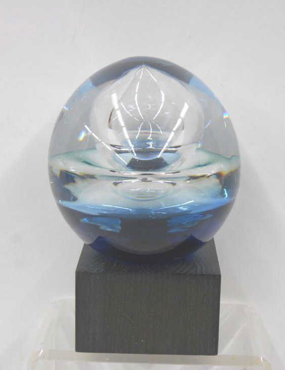 Goran Warff Kosta Boda Paperweight: Goran Warff designed for Kosta Boda, crystal and blue cased glass 8 1/4" (h) x 5" (l) paperweight that sits on top of a 2 1/2" (h) x 4" (l) x 4" (w) wood base, etched signature on base of paperweight