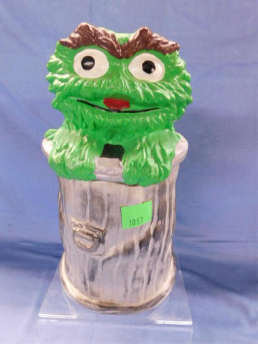 Oscar The Grouch Cookie Jar: Oscar The Grouch cookie jar, unmarked, with head and trash can lid form, trash can form jar, 11", hand painted. CONDITION: Minor wear, no chips or cracks.
