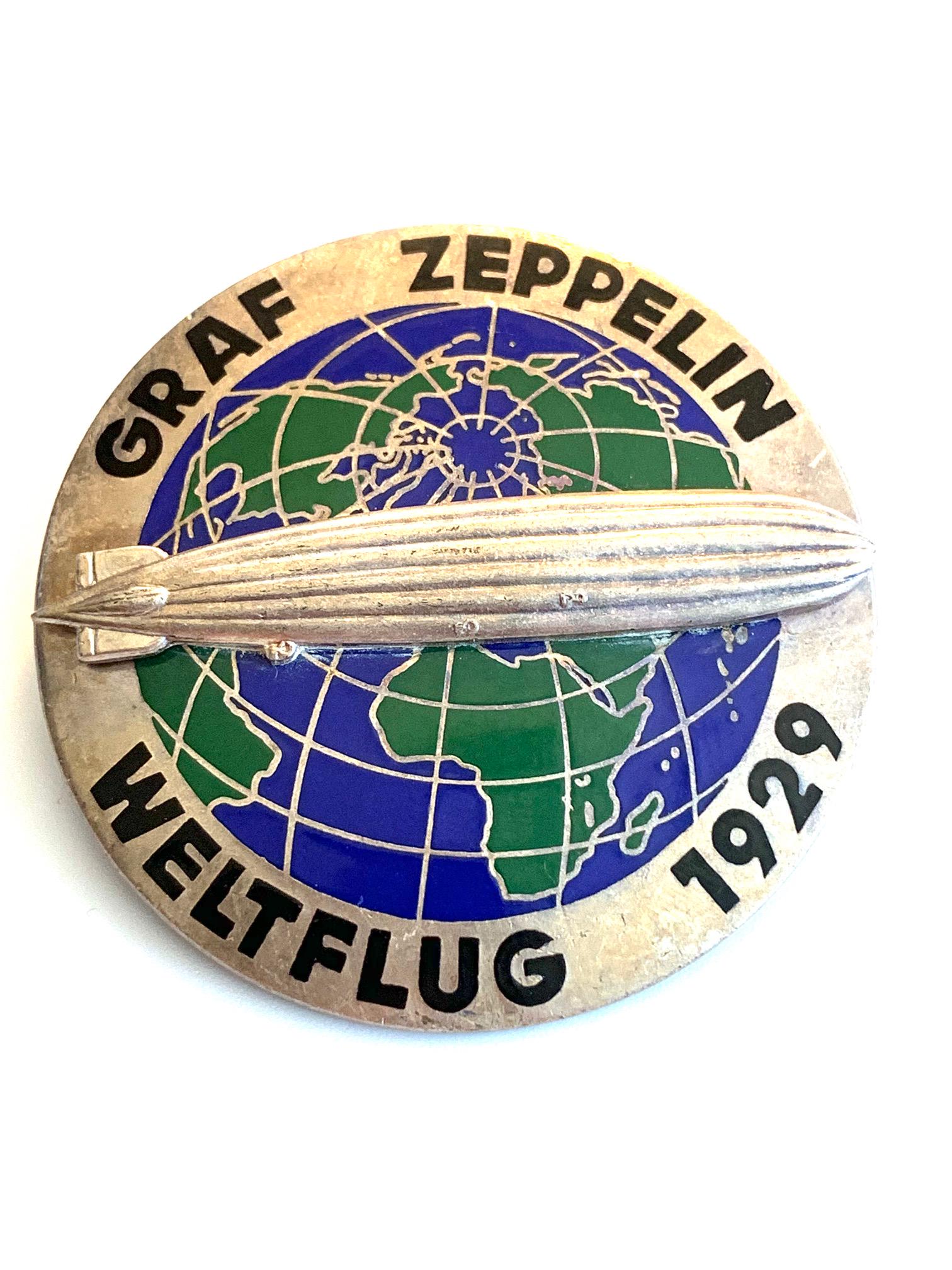 GERMANY AIRSHIP GRAF ZEPPELIN'S FIRST (1929) WORLD TOUR: The Graf Zeppelin was the first commercial German zeppelin began running regular routes in 1929. Measures 2" in diameter. The words "Graf Zeppelin" and "Weltflug 1929" are imprinted around the pin's e