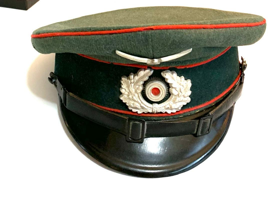 WWII GERMAN NAZI OFFICER'S VISOR CAP: WWII German Nazi Officer's Visor Cap with Red wool piping, shows appropriate wear and is marked 55 inside and is a green/grey color. A silver washed stamped alloy national eagle with out-stretched win