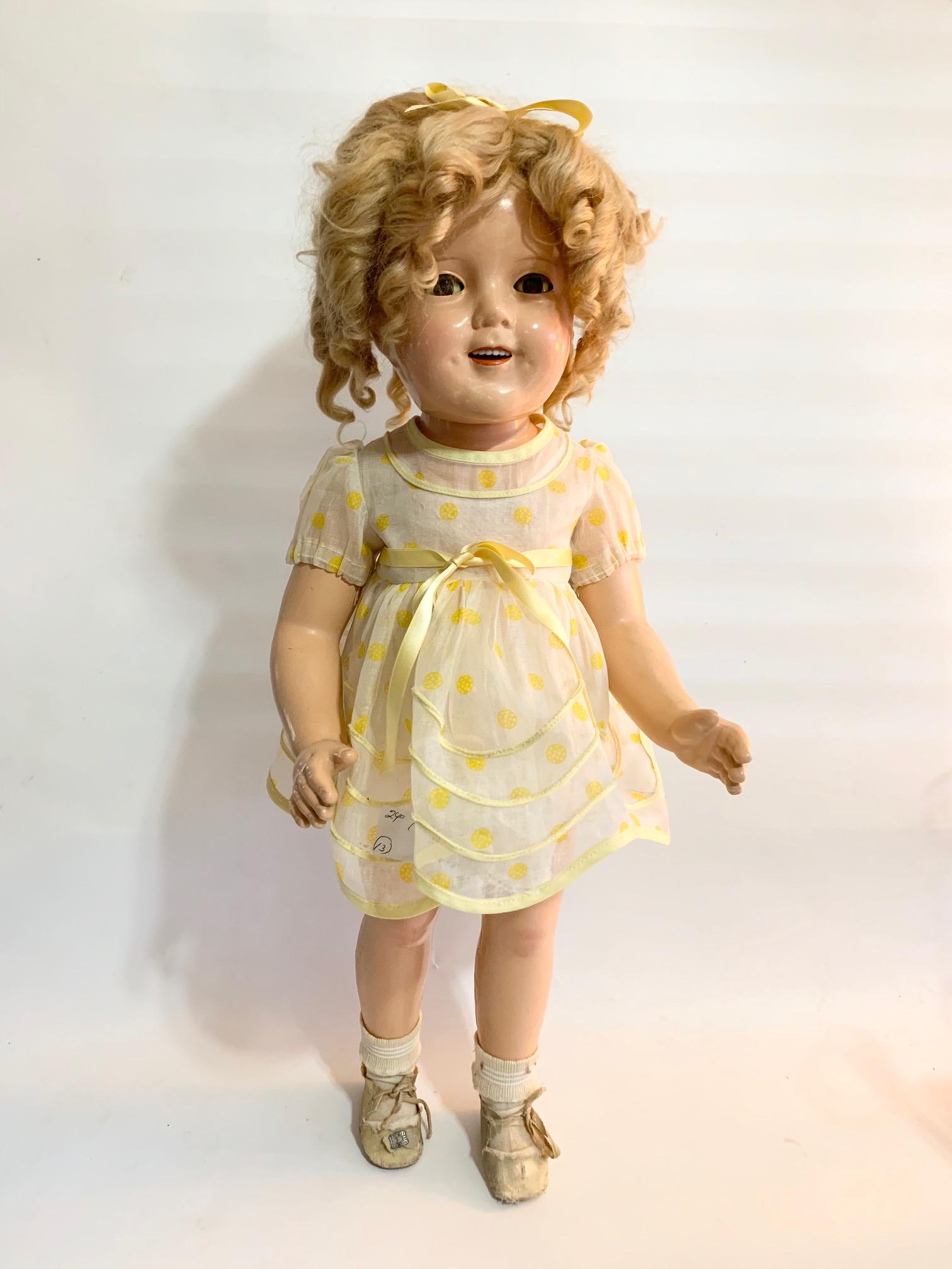 B6: Ideal Shirley Temple Little Rebel 24" Composition: Shirley Temple Little Rebel Ideal 24" composition doll; Marked on head; some crazing; Dress is not original and by Pattikins; wig probably not original. We do our best to list all possible flaws, thes