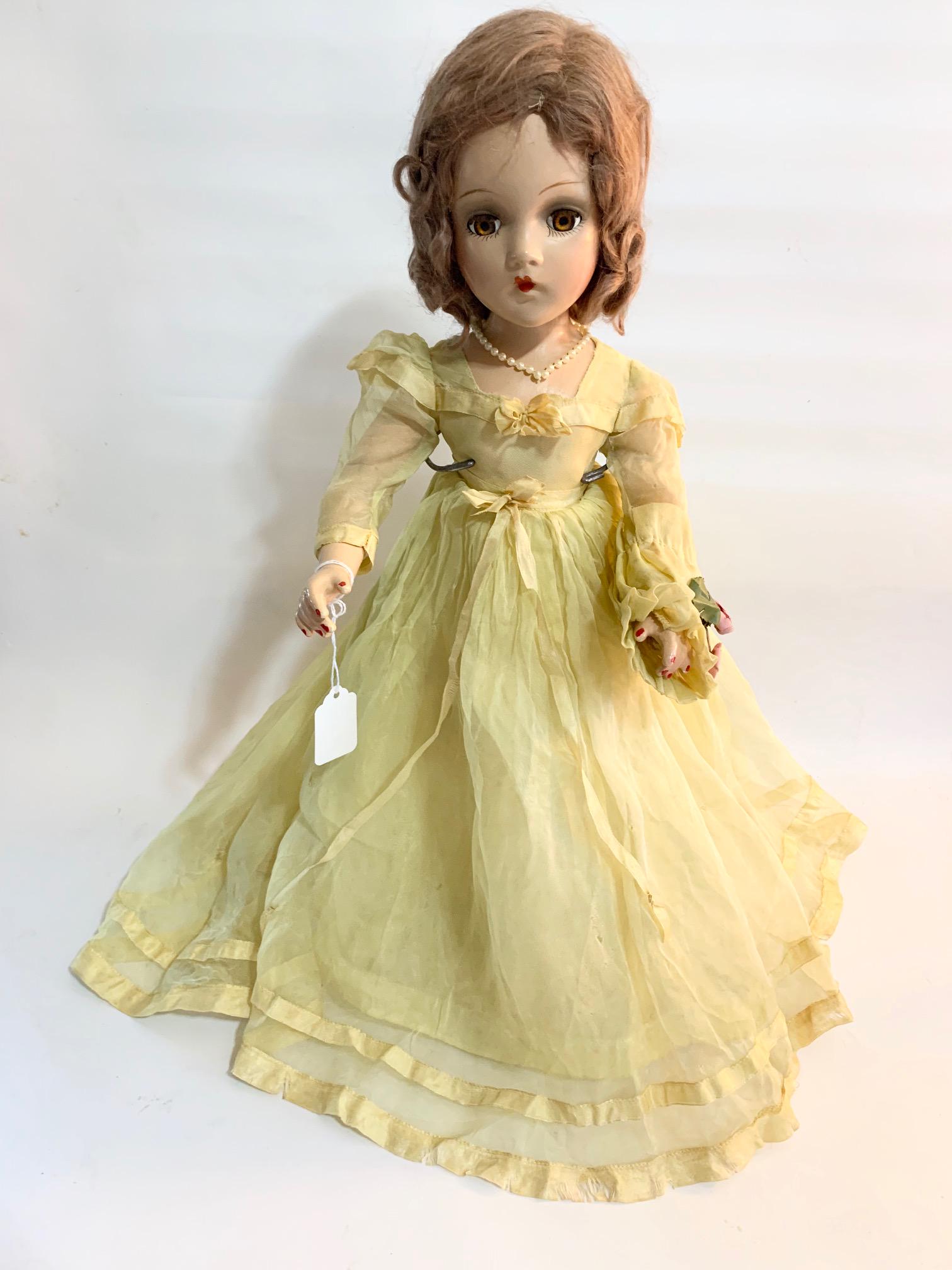 B7: Madame Alexander Bridesmaid 20" Composition: Madame Alexander yellow bridesmaid with Wendy Face; original tagged yellow dress; skirt has some damage (holes); decorative pearls; shoes replaced but old; original light brown mohair. We do our best 