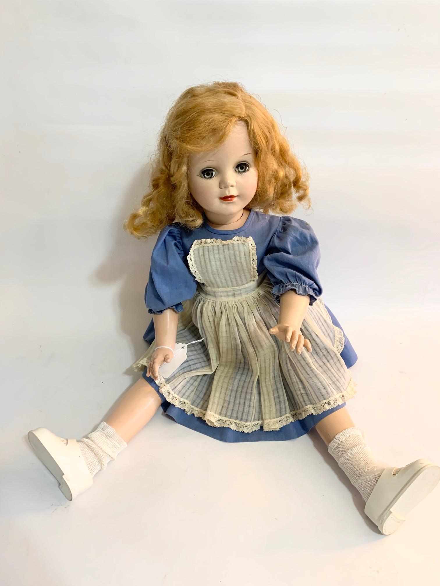 B7: Toni 23" Hard Plastic Doll Ideal: Toni 23" Hard Plastic Doll Ideal; Blue dress with white apron/pinafore; may not be original to doll; early synthetic hair. We do our best to list all possible flaws, these are vintage/antique dolls an