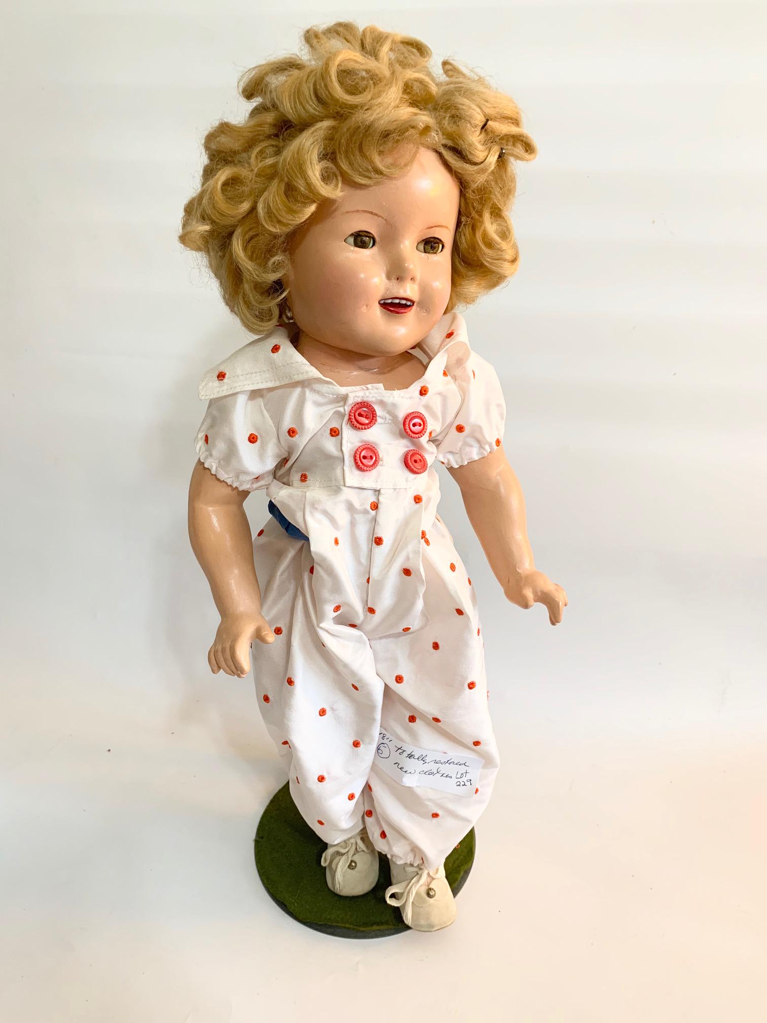 B-19: Shirley Temple 18" Composition Doll: Shirley Temple 18" Composition doll; face restored; replaced white jumpsuit with red embroidred polka dot; original wig. We do our best to list all possible flaws, these are vintage/antique dolls and 