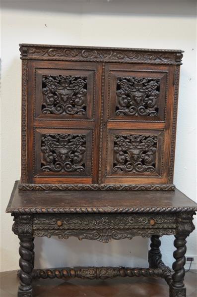 A Baroque Revival Oak & Mahogany Bookcase on Desk: Late 19th C. a relief griffin rinceaux frieze w/ applied corbel brackets, over two doors fitted with four pierced ribbon tied shields nestled among scrolls and whiplash tendrils w/ flowers, centering 