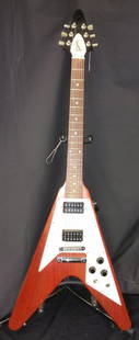 GIBSON FLYING V ELECTRIC GUITAR: Gibson’s Iconic Flying V, manufactured in the USA. Serial number 00235305. Guitar has minimal wear, slight dings, and an attached pick holder. Overall very good condition. Includes Gibson soft gig b