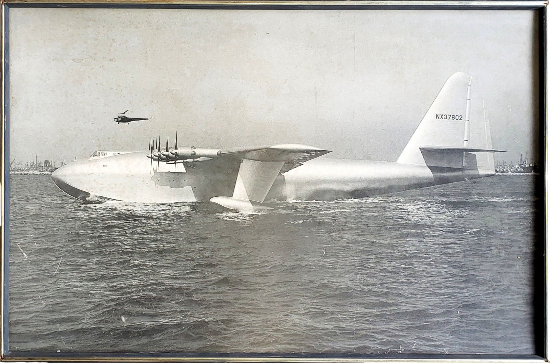 Large Spruce Goose Black and White Print - Framed: Black and white reprint of a photo of \"The Spruce Goose\" the wood plane created by Howard Hughes. The Hughes H-4 Hercules was a prototype strategic airlift flying - boat designed and built by the Hu