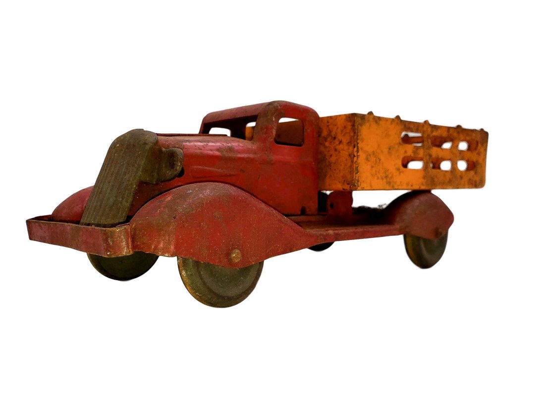 1930s Pressed Steel Stake Bed Truck - Wood Wheels: Attributed to Marx / Wyandotte red and orange paint scheme pressed steel stake bed truck. Original wooded wheels, the paint appears original, rolls freely, surface rust and patina of use, wear, and ag