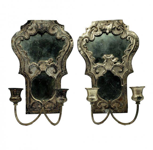 Matched Pair of Vintage Florentine Mirrored Sconces: Flourishes and scrolling details of Florentine style.Silver wash over the tin on wooded supports. Each holds two candles reflected in silver-backed mirrors with authentic age, tarnish and wear spots. 