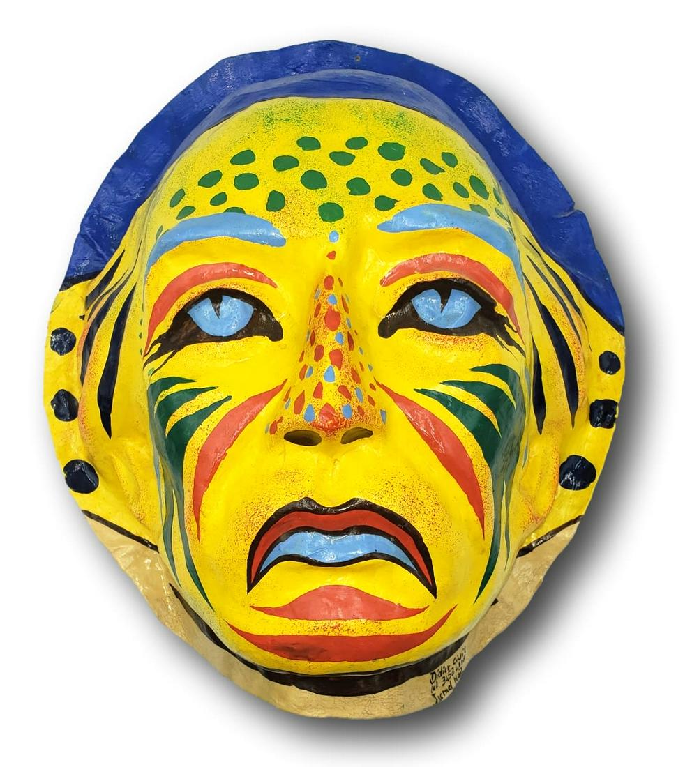 Signed Didier Civil Mardi Gras Mask: Primarily a yellow Mardi Gras papier-mache mask by artist Didier Civil, signed, numbered, and made in Jacmel Haiti. Fine condition, no issues noted. A pinhole threaded with clear nylon string allows f
