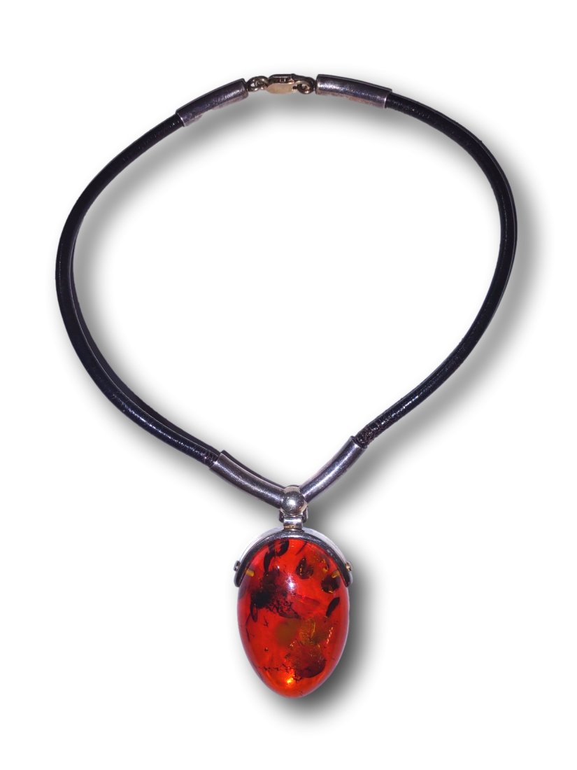 Baltic Amber and Silver Necklace: A statement pendant of 1.5 x 2 inches, Baltic Amber suspended by a silver hinge on a black leather choker length necklace, marked sterling on the clasp. Please refer to the images for the best determi