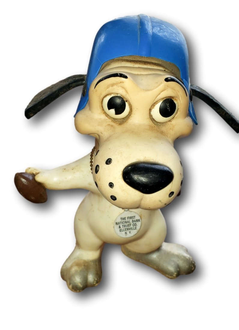 Vintage Advertising Dog Coin Bank with Football Helmet Ellenville NY: This charming vintage coin bank features a whimsical dog character, donning a blue football helmet and wielding a hammer. Made from durable plastic, this bank stands out with its playful design and ex