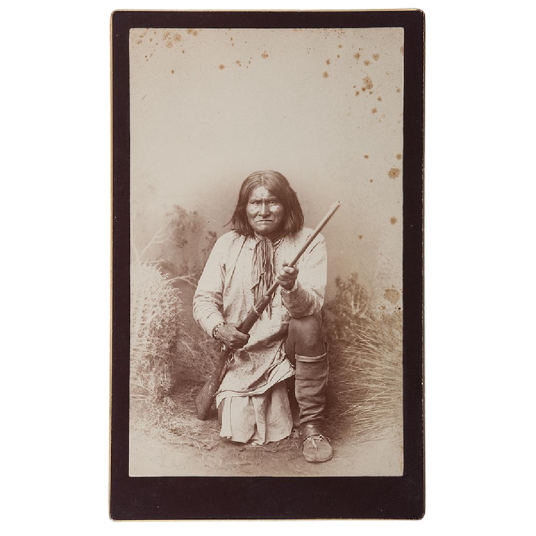 Geronimo Boudoir Card by Randall: Albumen boudoir card of Geronimo kneeling, holding an 1873 Springfield carbine rifle. Verso copyright label of A.F. Randall, dated 1885, overstamped by A.M. Blackwell of Las Vegas, NM. A.F. Randall wo